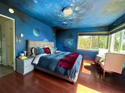 a blue bedroom with a bed with a blue ceiling at Shangri-La Oceanfront vacation home in Pender Island