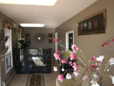 a living room with a vase with pink flowers in it at King's Motel & Restaurant in St. Paul
