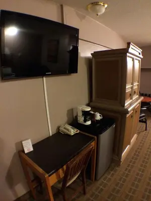 a hotel room with a table and a television on the wall at King's Motel & Restaurant in St. Paul