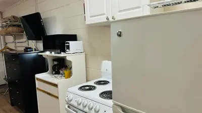 a small kitchen with a stove and a microwave at Travellers Motel in Cranbrook