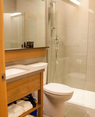 a bathroom with a toilet and a shower and a sink at Kwa'lilas Hotel in Port Hardy