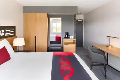 a hotel room with a bed and a desk at Kwa'lilas Hotel in Port Hardy