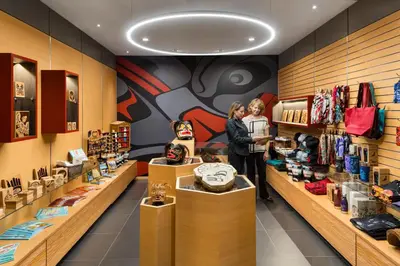 two women are standing in a store with a clock at Kwa'lilas Hotel in Port Hardy
