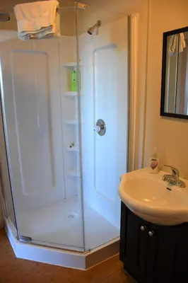 a bathroom with a shower and a sink at North Coast Trail Backpackers Ltd in Port Hardy