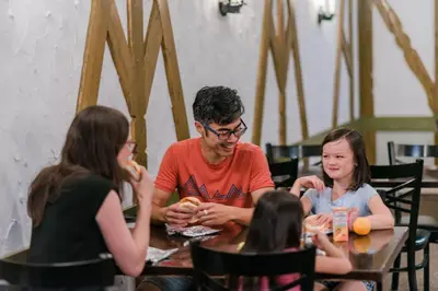 a group of people sitting at a table eating food at Mountaineer Lodge in Lake Louise