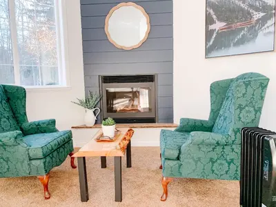 a living room with two chairs and a table at The Inn at the Ninth Hole Bed & Breakfast in Salmon Arm