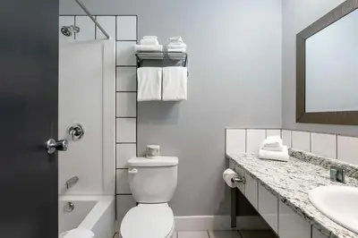a bathroom with a toilet and a sink and a mirror at Stoke Hotel SureStay Collection by Best Western in Revelstoke