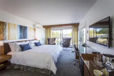 a bedroom with a bed and a desk and a television at Qualicum Beach Inn in Qualicum Beach