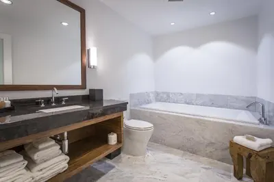 a bathroom with a tub and a toilet and a sink at Qualicum Beach Inn in Qualicum Beach