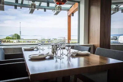 a table with wine glasses on it with a view at Qualicum Beach Inn in Qualicum Beach