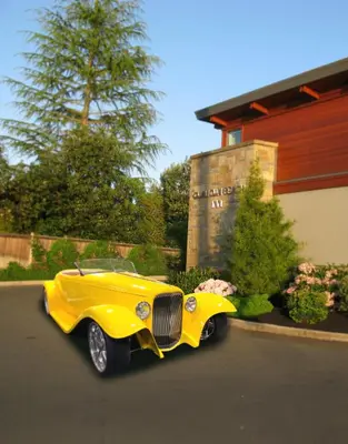 a yellow car is parked in front of a building at Qualicum Beach Inn in Qualicum Beach