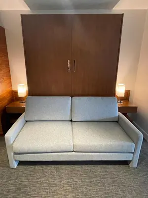 a couch sitting in a room with two tables at Qualicum Beach Inn in Qualicum Beach