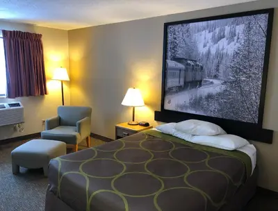 a hotel room with a bed and a large screen at Super 8 by Wyndham Salmon Arm in Salmon Arm