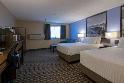 a hotel room with two beds and a flat screen tv at Super 8 by Wyndham Kamloops On The Hill in Kamloops