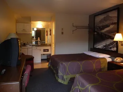 a hotel room with two beds and a kitchen at Super 8 by Wyndham Kamloops East in Kamloops