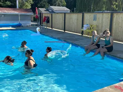 a group of people in a swimming pool with a whale in the water at Paradise Motel in Sicamous