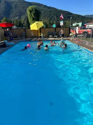 a group of people swimming in a swimming pool at Paradise Motel in Sicamous