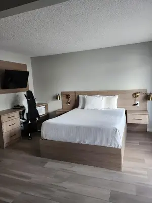 a bedroom with a bed and a desk and a television at Paradise Motel in Sicamous