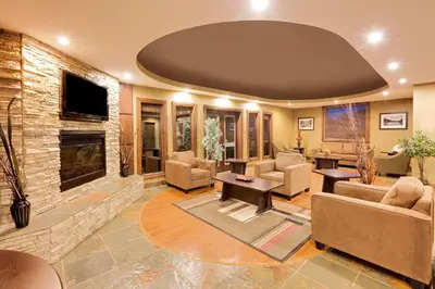 a living room with couches and a fireplace at Ramada by Wyndham Cold Lake in Cold Lake