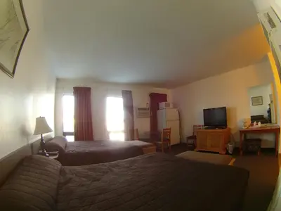 a hotel room with two beds and a television at Rycroft Hotel in Rycroft