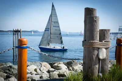 a sail boat in the water next to a pier at Sidney Waterfront Inn & Suites in Sidney