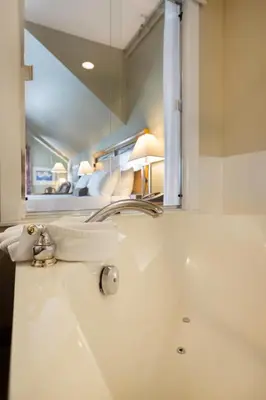 a bathroom with a sink and a mirror at Sidney Waterfront Inn & Suites in Sidney