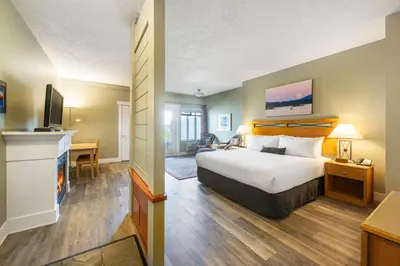 a hotel room with a bed and a television at Sidney Waterfront Inn & Suites in Sidney
