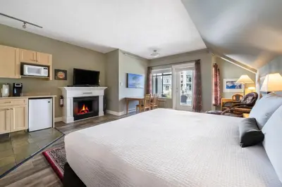 a bedroom with a large bed and a fireplace at Sidney Waterfront Inn & Suites in Sidney