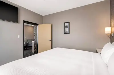 a bedroom with a white bed and a sliding door at Comfort Inn & Suites in North Battleford