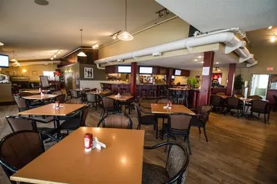 a restaurant with tables and chairs in a room at Nova Inn Acheson in Spruce Grove