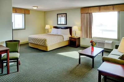 a hotel room with a bed and a chair at Nova Inn Acheson in Spruce Grove