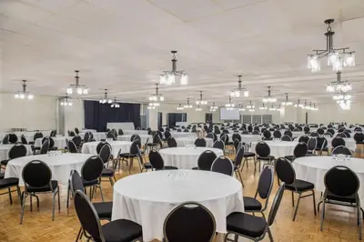 a banquet hall with white tables and chairs and chandeliers at Days Inn & Conference Centre by Wyndham Camrose Norsemen in Camrose