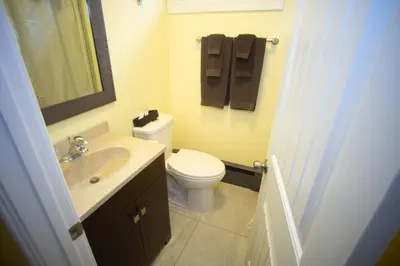 a bathroom with a toilet and a sink and a mirror at Stardust Motel in Camrose
