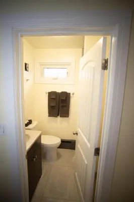 a bathroom with a toilet and a sink and a window at Stardust Motel in Camrose