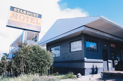a building with a sign that reads paranoid motel at Stardust Motel in Camrose