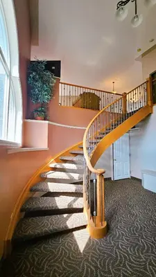 a spiral staircase in a building with a large window at Misty Mountain Inn & Suites in Grande Cache