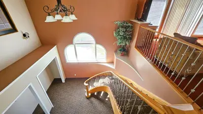 a hallway with a staircase with two windows and a stair case at Misty Mountain Inn & Suites in Grande Cache