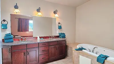 a bathroom with a tub and a large mirror at Misty Mountain Inn & Suites in Grande Cache