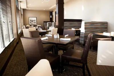 a restaurant with tables and chairs in a room at Holiday Inn Hotel & Suites Red Deer by IHG in Red Deer