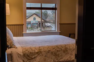a bedroom with a bed in front of a window at Salt Spring Inn in Ganges