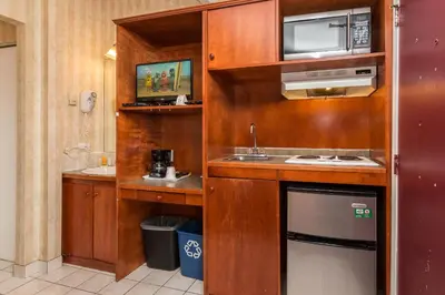 a small kitchen with a sink and a microwave at Canadas Best Value Inn Chinook Station in Calgary