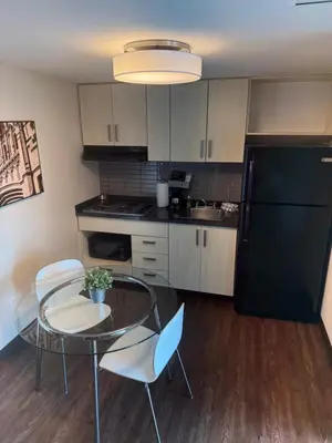 a kitchen with a table and chairs and a black refrigerator at SAIT Residence & Conference Centre - Calgary in Calgary
