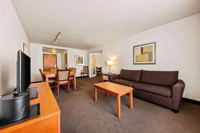 a living room with a couch and a dining room at Wingate by Wyndham Calgary South in Calgary