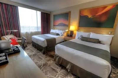 a hotel room with two beds and a desk at River Rock Casino Hotel in Richmond