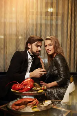a man and a woman sitting at a table with food at EXchange Hotel Vancouver in Vancouver
