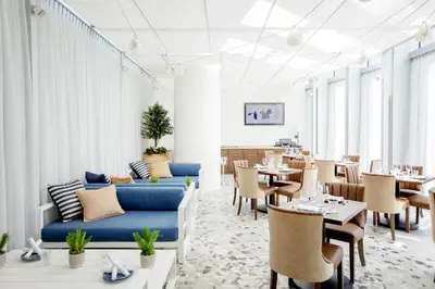 a restaurant with a blue couch and tables and chairs at EXchange Hotel Vancouver in Vancouver