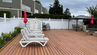 a deck with chaise lounges and a table and chairs at Buena Vista by the Sea in Qualicum Beach