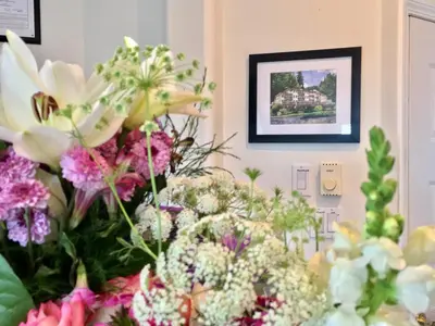a bunch of flowers in a room with a picture at Casa Grande Inn in Qualicum Beach