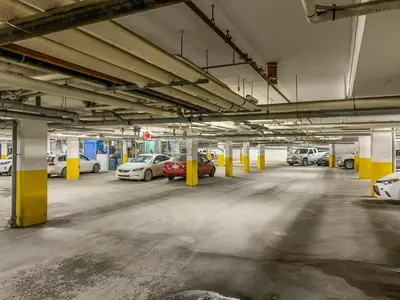 an empty parking garage with cars parked in it at Inviting Rocky Mountain HOT TUB in Top Rated Condo managed by Little Sister Getaways in Canmore