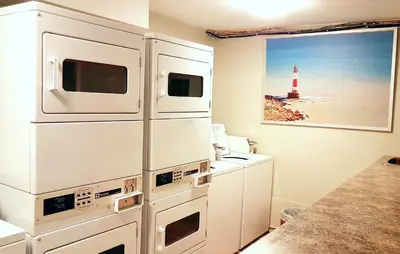 a kitchen with white appliances and a lighthouse at Riverside Resort & RV Park in Qualicum Beach